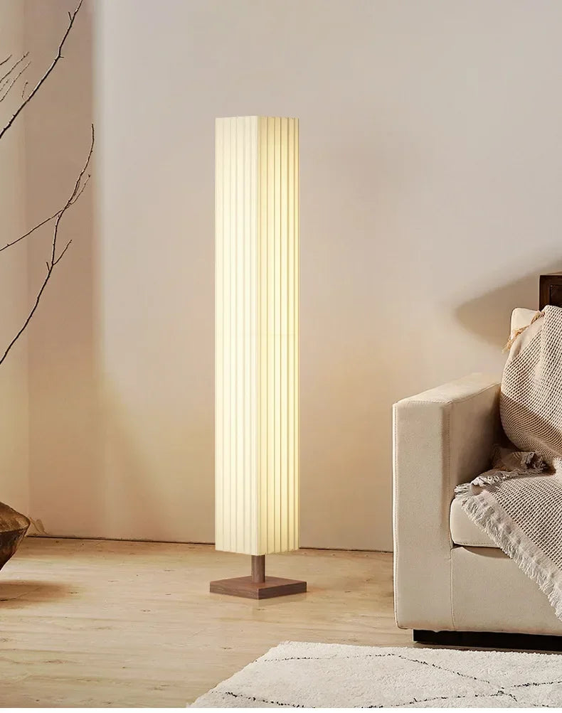 Floor lamp in a living room setting with a sofa and decorative elements.