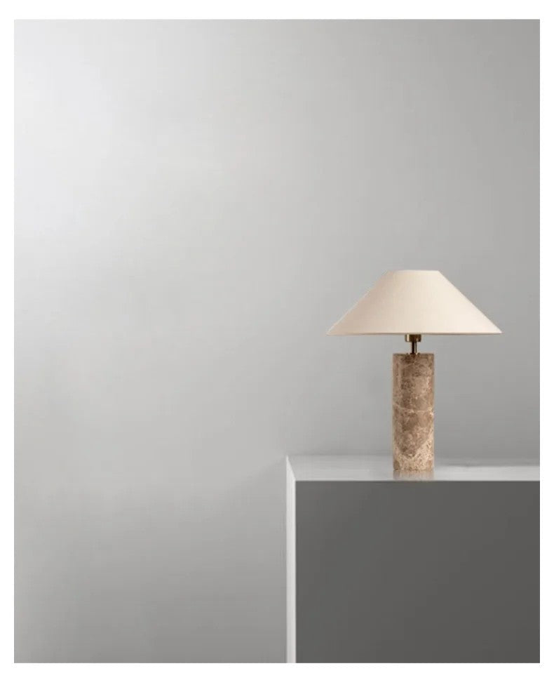 Table lamp with a textured base on a gray surface against a light gray background