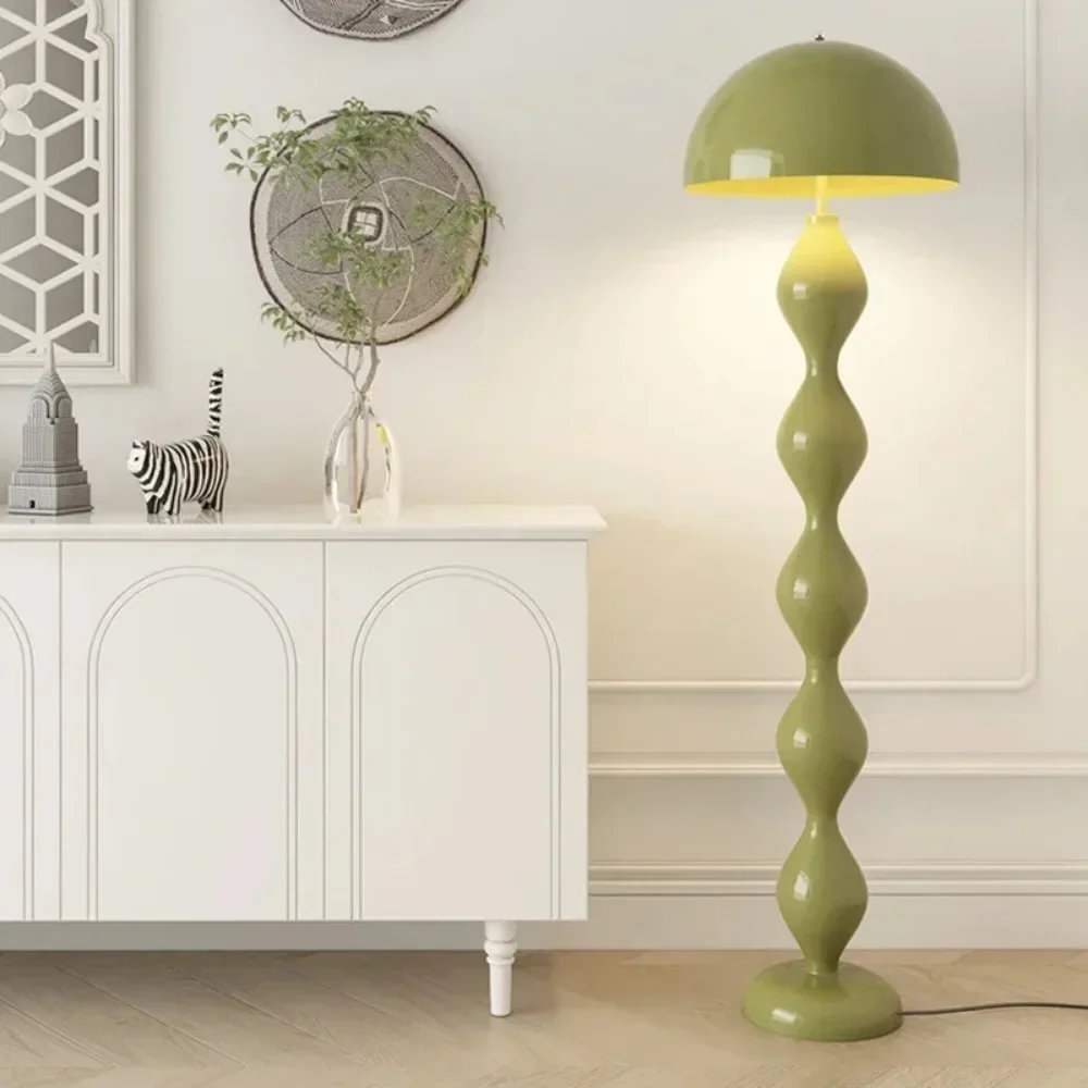 Green floor lamp in a room with a white cabinet and decorative items.