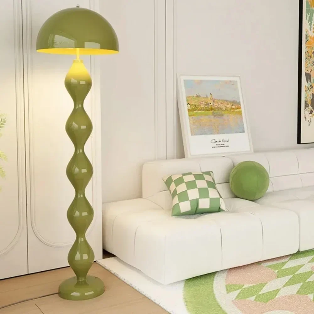 Green floor lamp in a living room with a white sofa and decorative pillows.