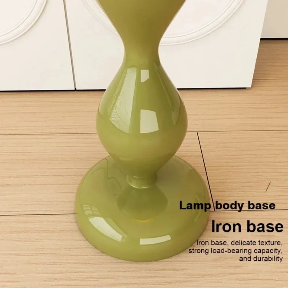 Green lamp body base on a wooden floor with text describing its features.