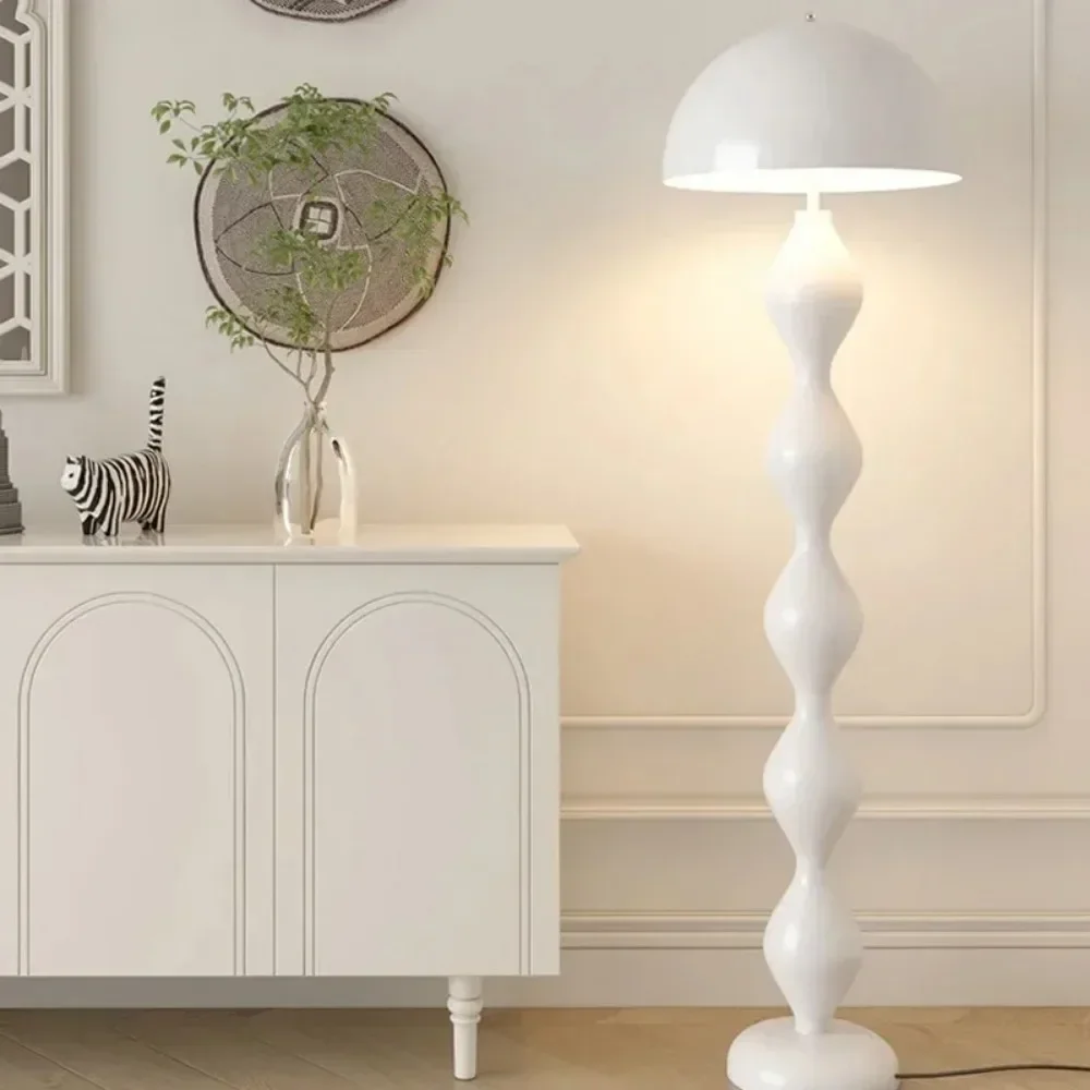 White floor lamp in a room with a white cabinet and decorative items.