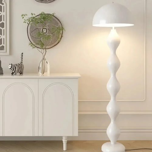 White floor lamp in a room with a white cabinet and decorative items.