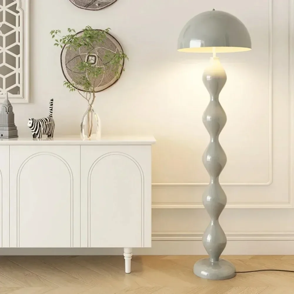 Gray floor lamp in a room with a white cabinet and decorative items.