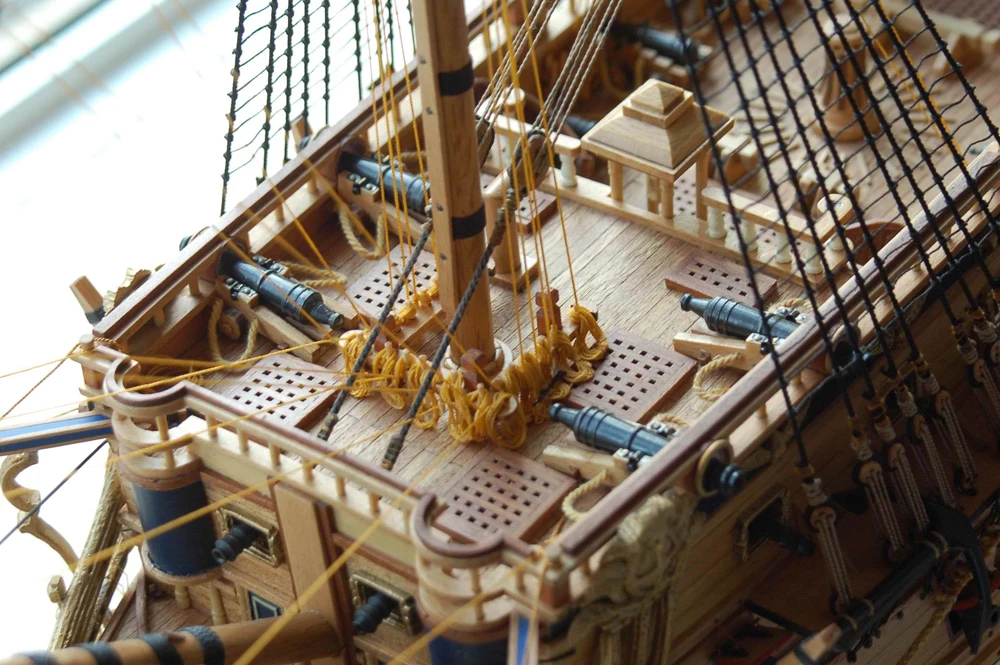 Close-up of a model ship with detailed rigging and cannons.